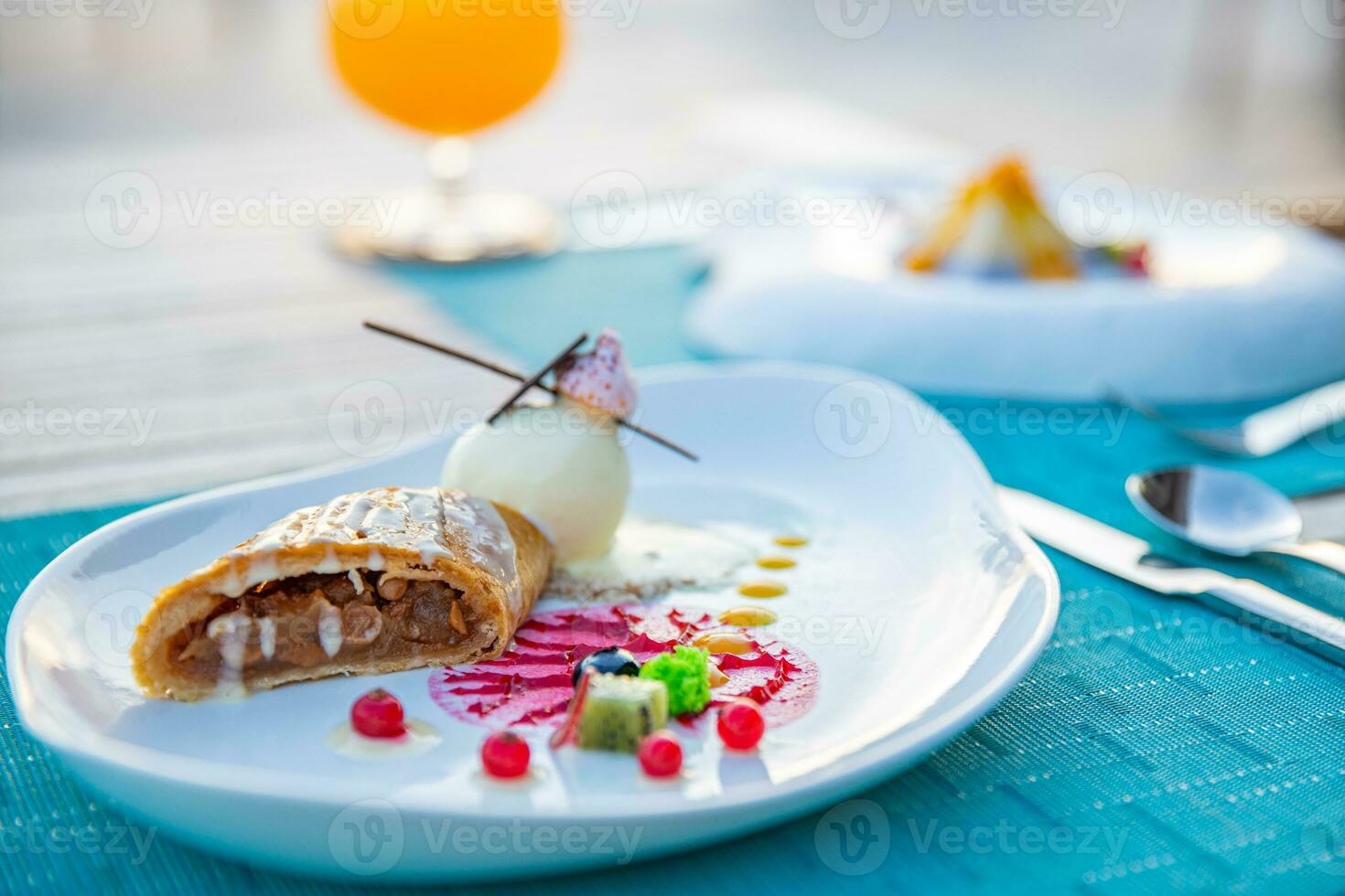 Gourmet dessert ice cream and cake with fruits on elegant close-up view. Plate with different sweet desserts and cocktails on colorful table photo