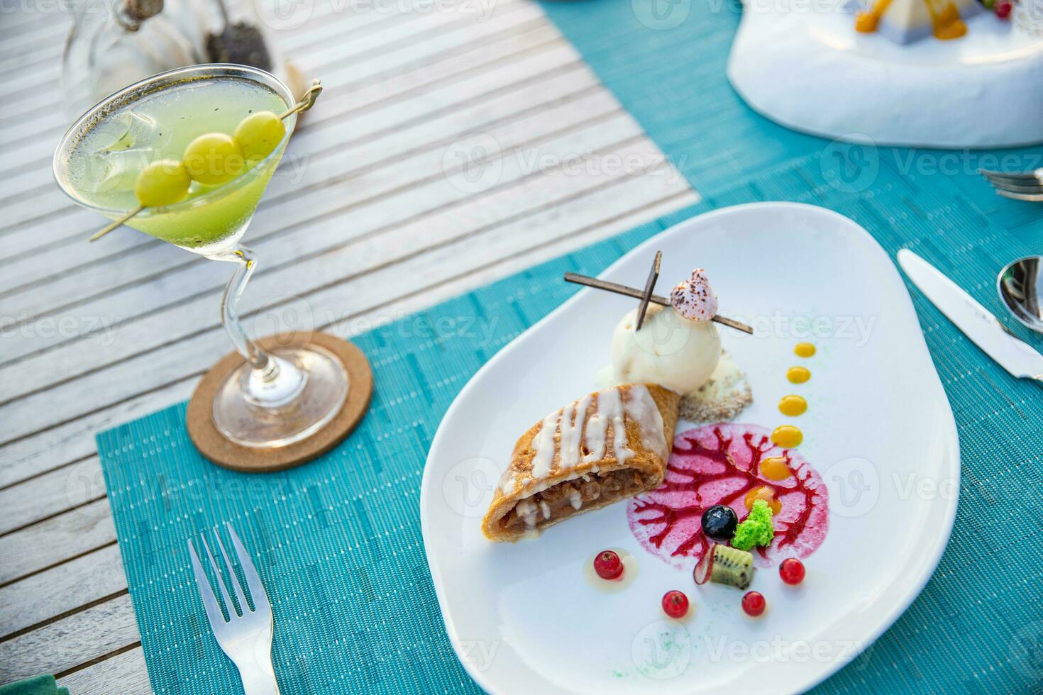 Gourmet dessert ice cream and cake with fruits on elegant close-up view. Plate with different sweet desserts and cocktails on colorful table photo