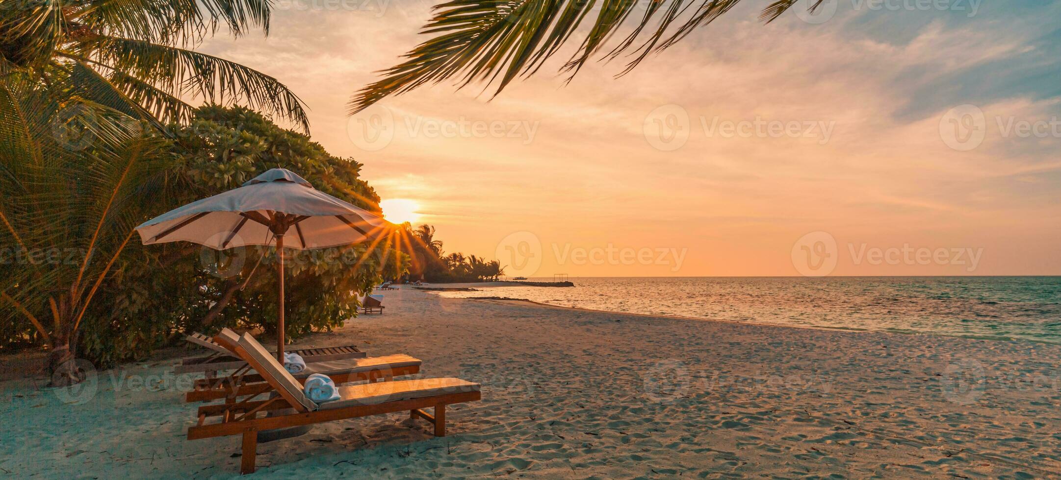 Amazing sunset beach. Romantic couple chairs umbrella. Tranquil togetherness love wellbeing, relax beautiful landscape design. Getaway tropical island coast palm leaves idyllic sea photo