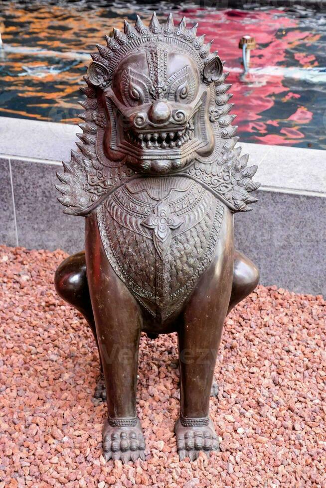 a statue of a lion sitting on a stone photo