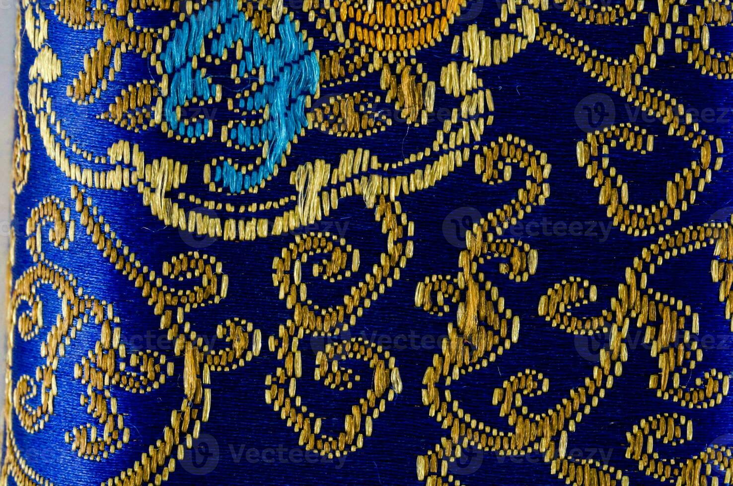 a close up of a blue and gold patterned fabric photo