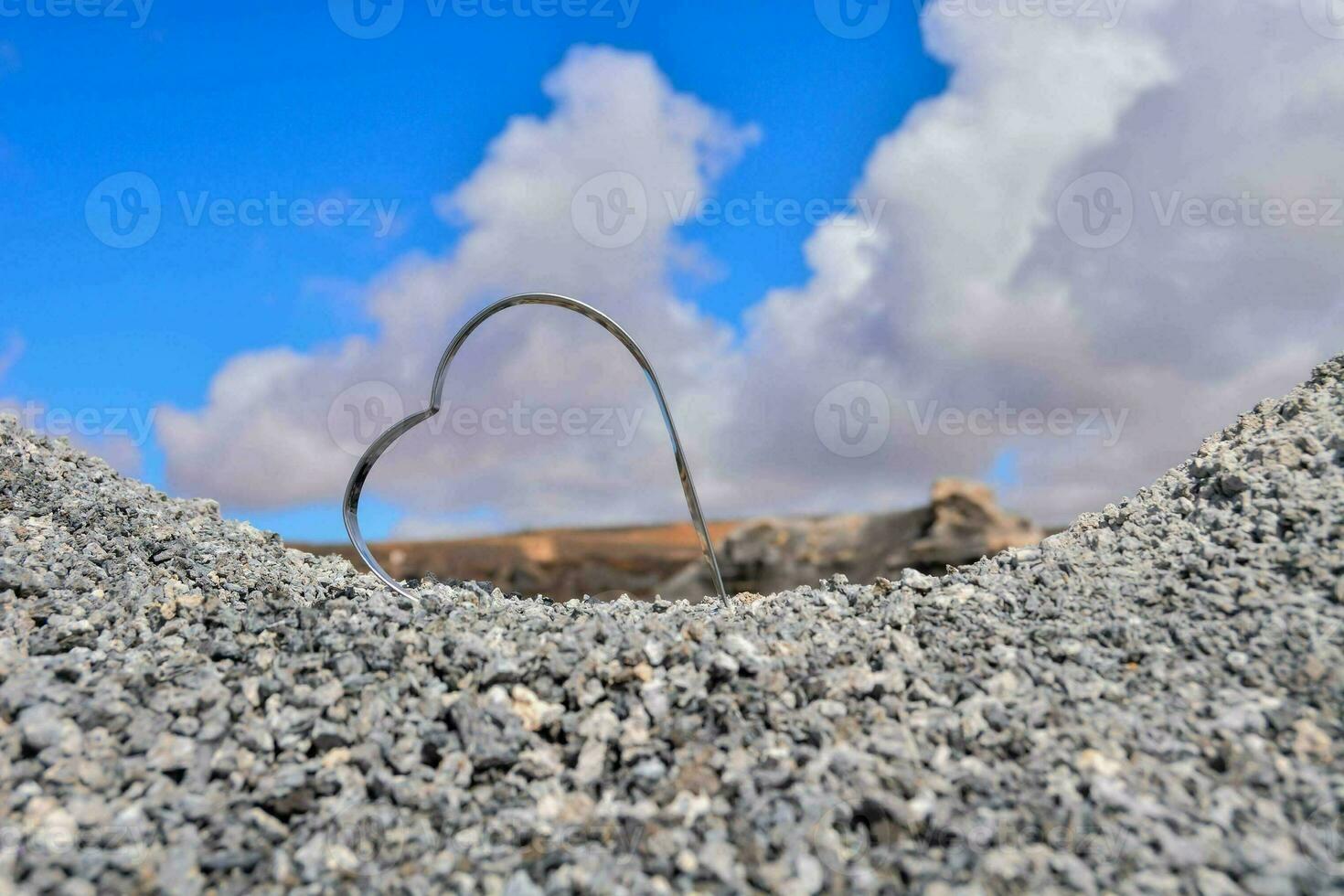 un corazón conformado agujero en el suelo con un azul cielo en el antecedentes foto