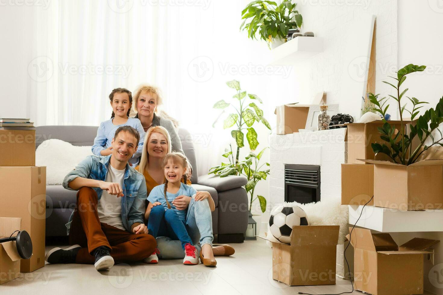 Portrait of nice attractive lovely charming cheerful big full family sitting mom dad making roof new apartment move photo
