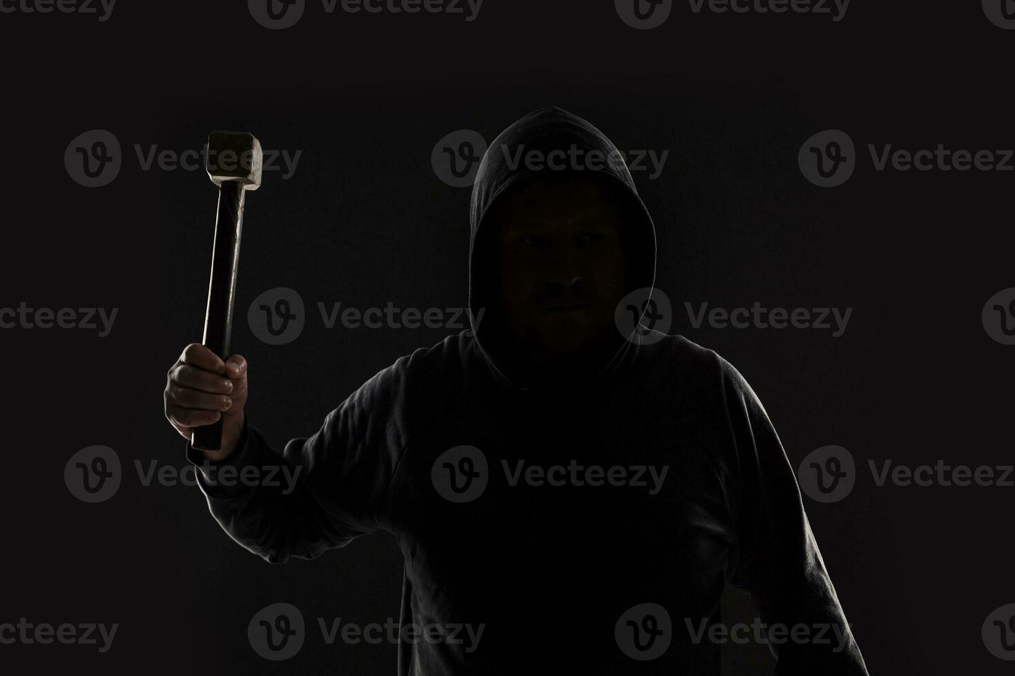 Criminal in dark clothes and balaclava with hammer photo