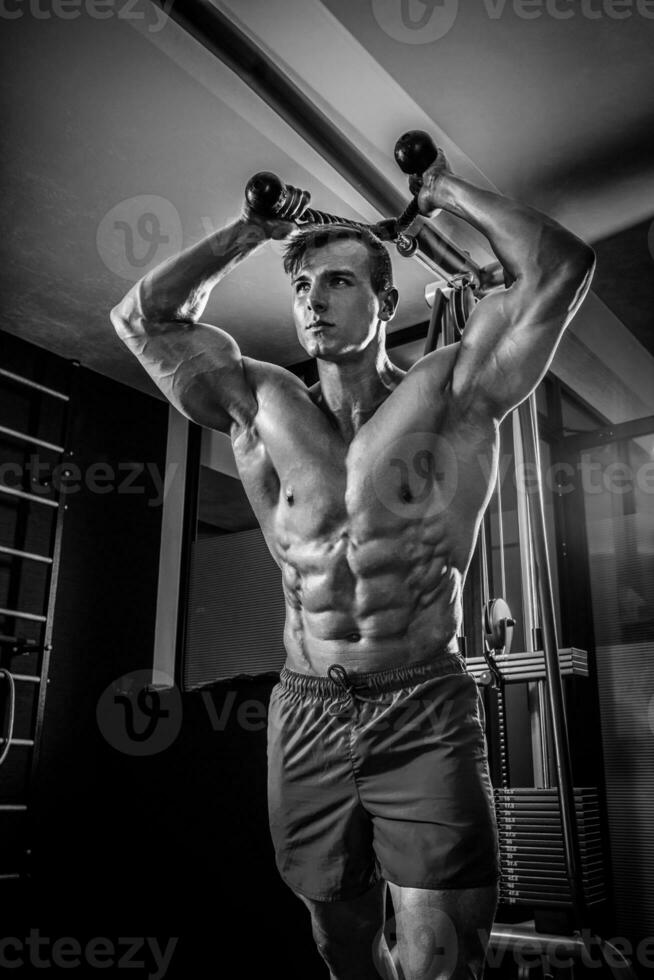 Sexy muscular man posing in gym, shaped abdominal. Strong male n photo