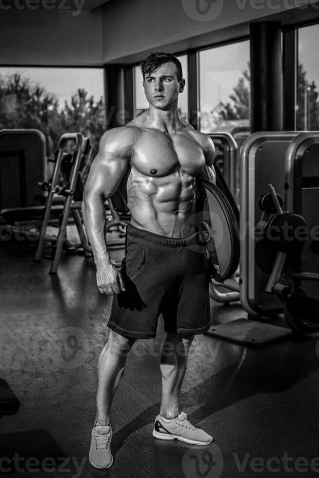 Sexy muscular man posing in gym, shaped abdominal. Strong male n photo