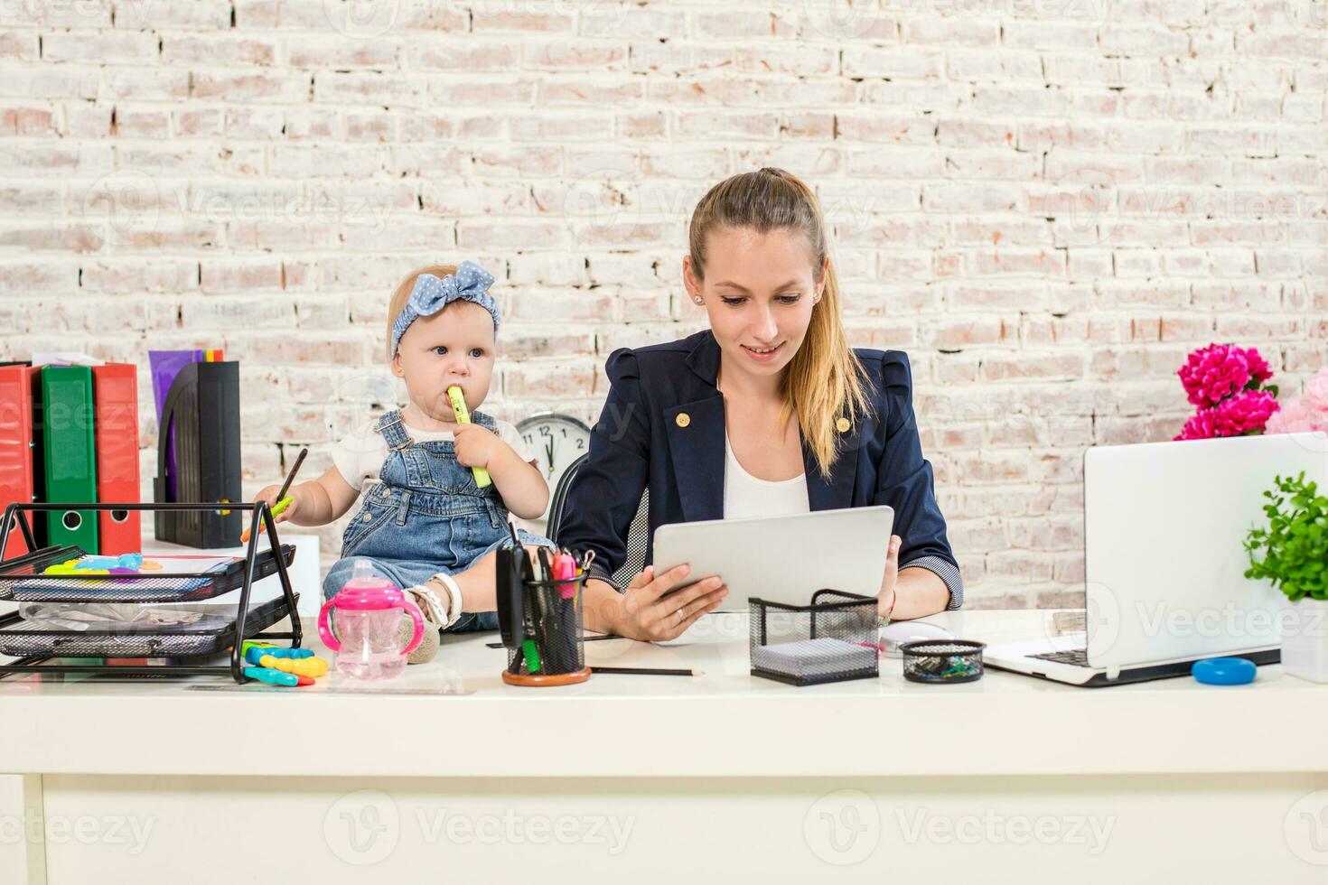Mom and businesswoman working with laptop computer at home and playing with her baby girl. photo