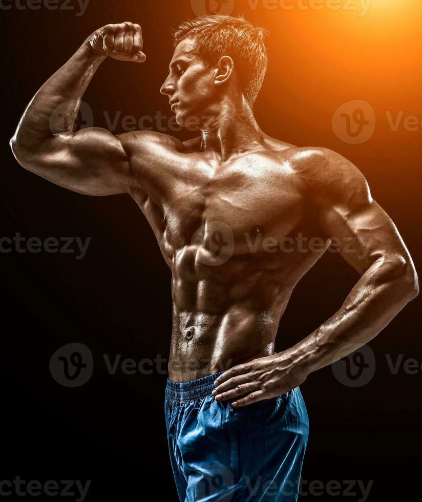 Muscular and fit young bodybuilder fitness male model posing ove photo