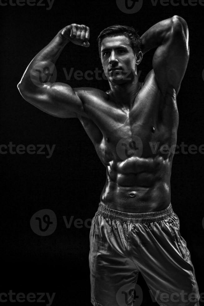 Muscular and fit young bodybuilder fitness male model posing ove photo