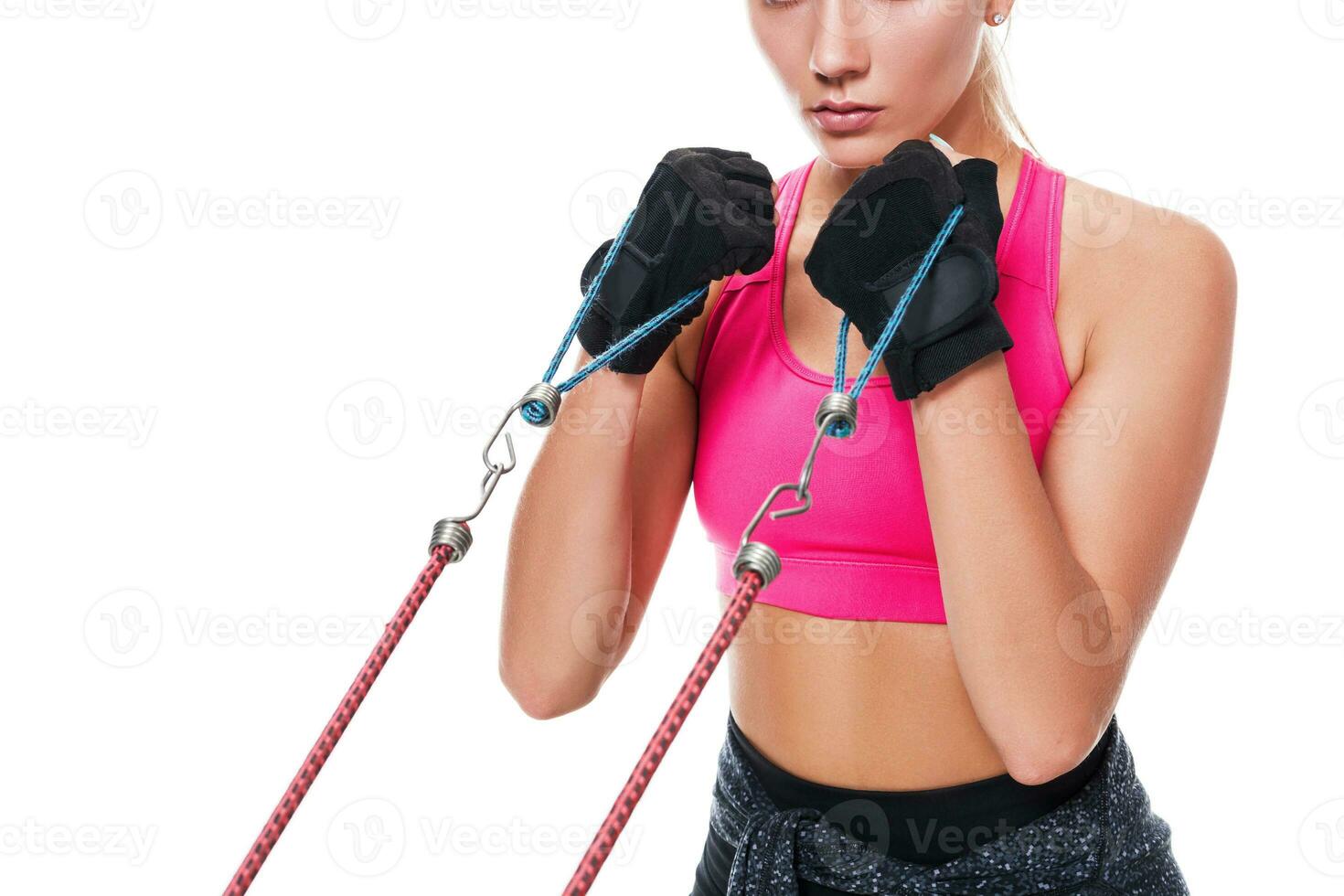 Strong woman using a resistance band in her exercise routine. Young woman performs fitness exercises on white background. Close up photo