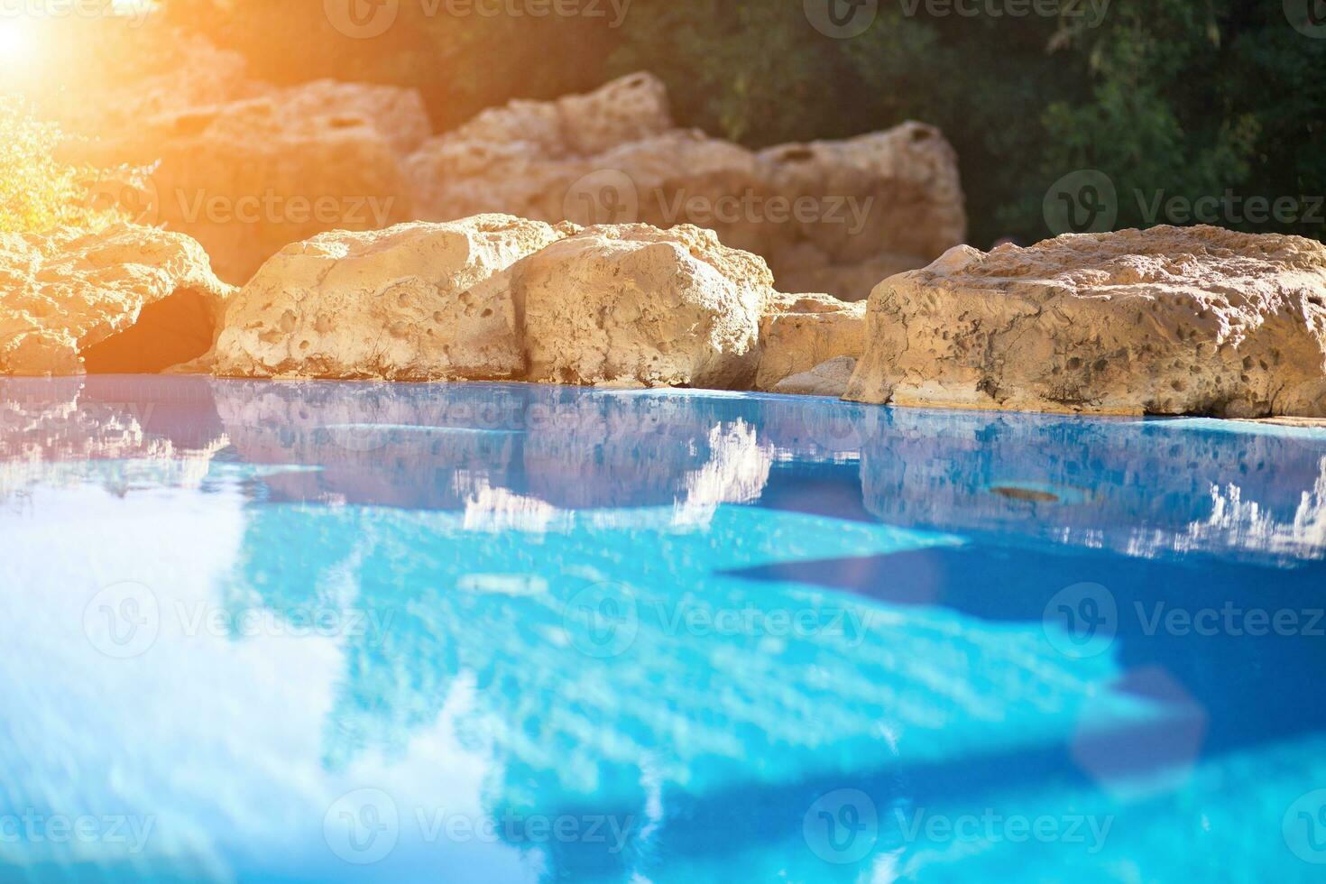 Outdoor inground residential swimming pool in backyard with hot tub. Sun flare photo
