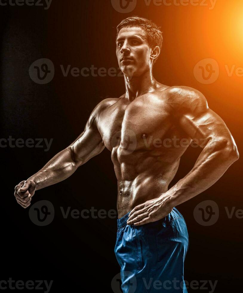 Muscular and fit young bodybuilder fitness male model posing ove photo
