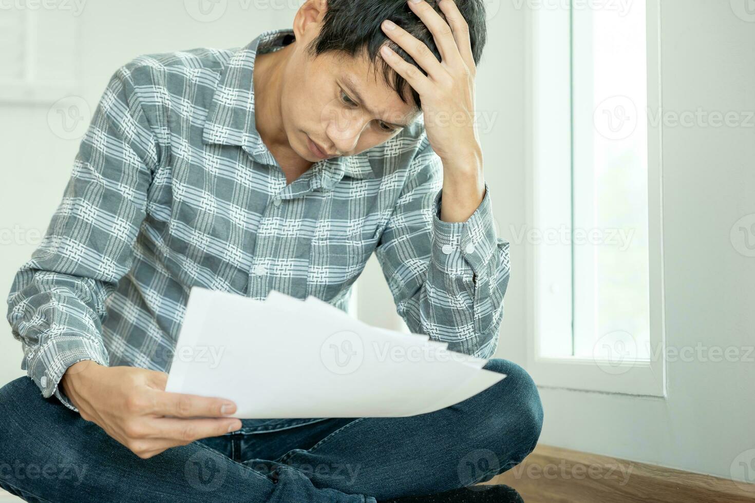 Stressed and headache asian man with large bills or invoices no money to pay to expenses and credit card debt. shortage, Financial problems, mortgage, loan, bankruptcy, bankrupt, poor, empty wallet photo