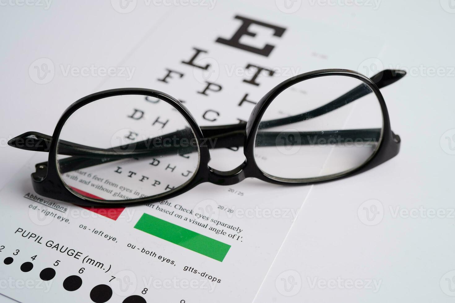 Glasses on eye exam chart to test eyesight accuracy of reading. photo