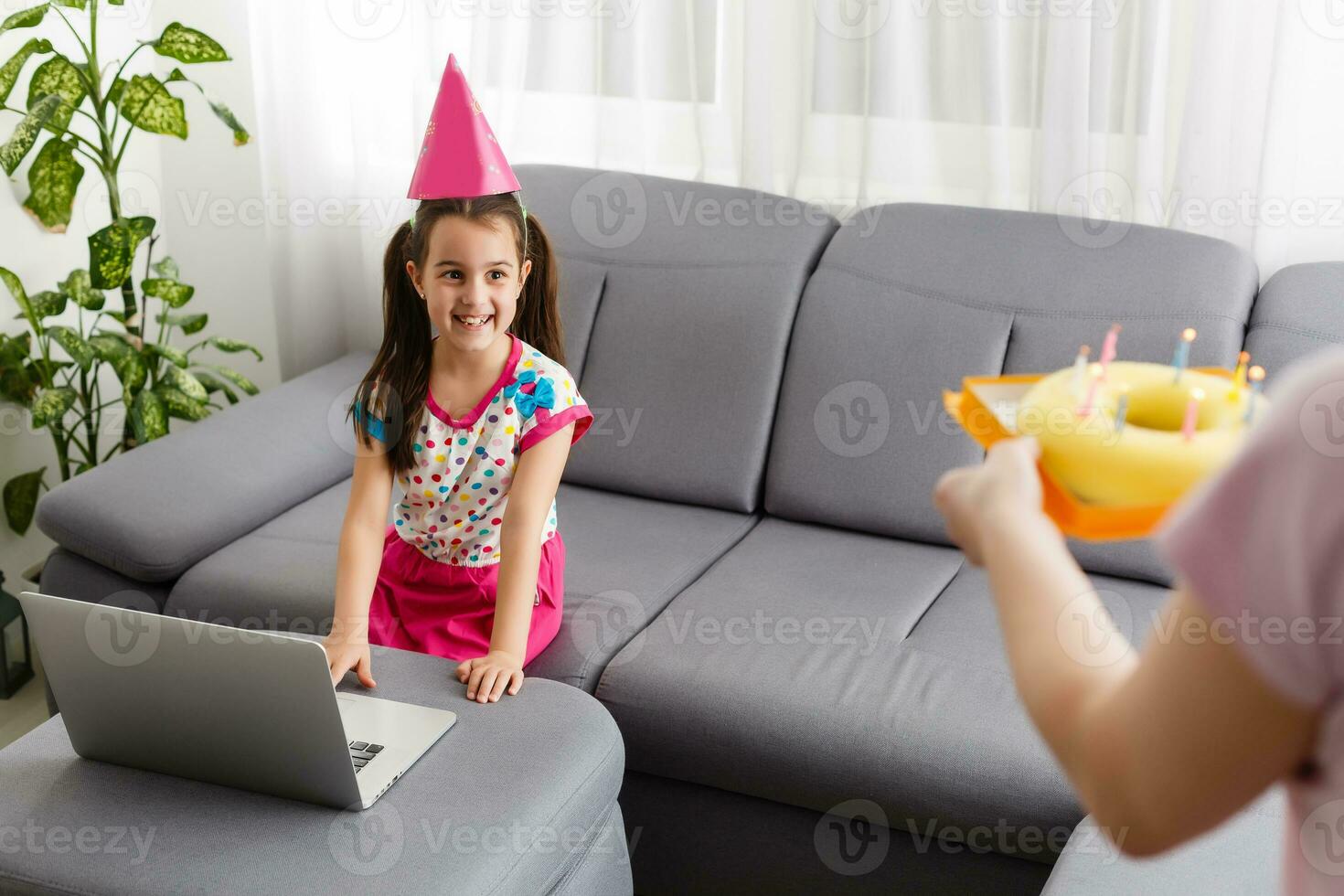 Happy girl sibling celebrating birthday via internet in quarantine time, self-isolation and family values, online birthday party. Congratulations animator via laptop, online. Stay at home photo