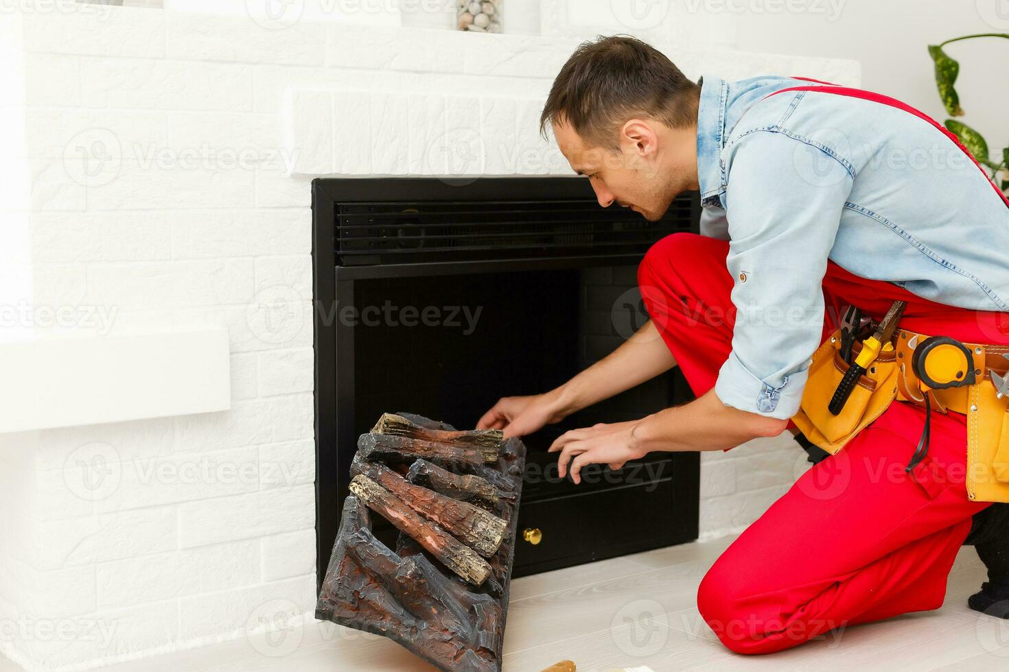repairman repairs and installs a fireplace in the apartment photo