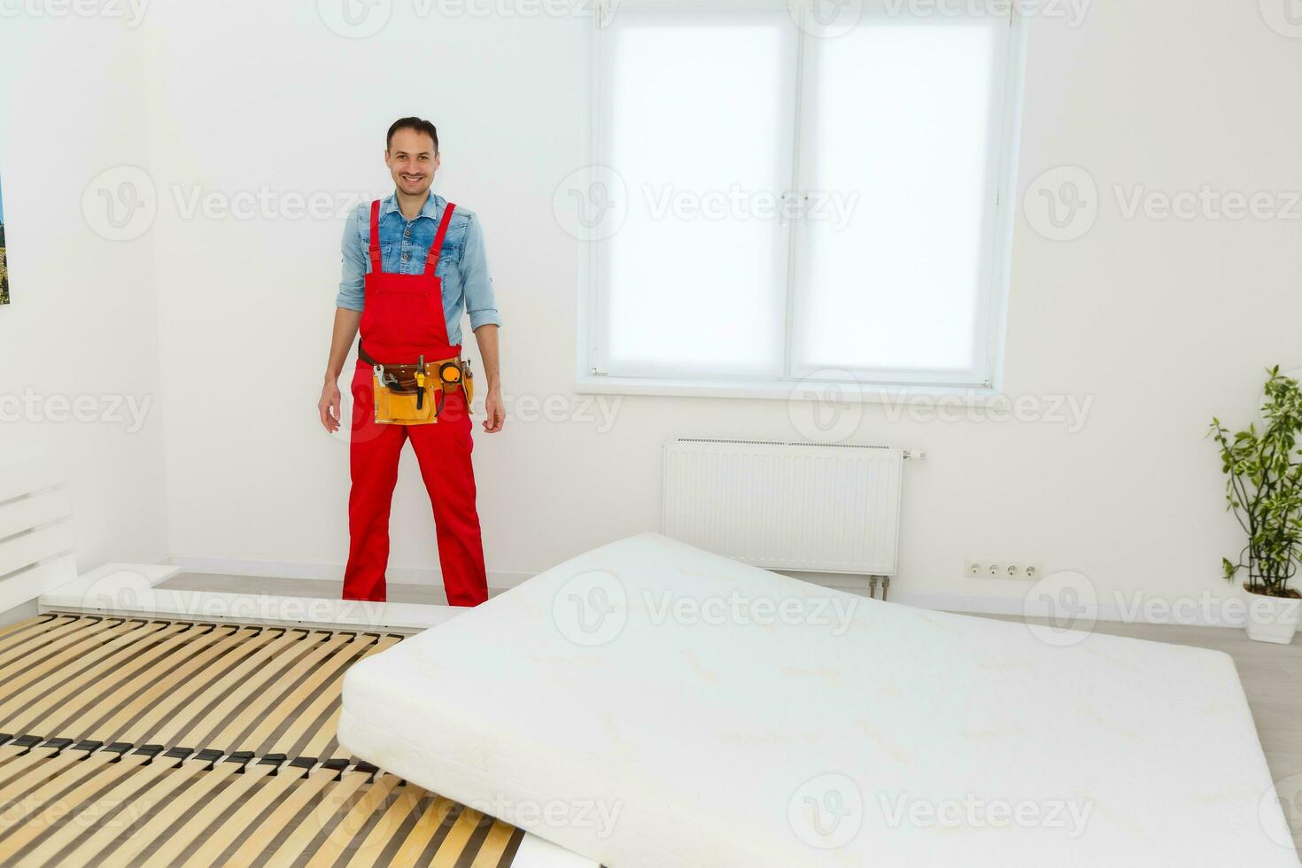 Man's hands working with a hex key. Assembling furniture. Wooden plank of a bed. Close up. photo