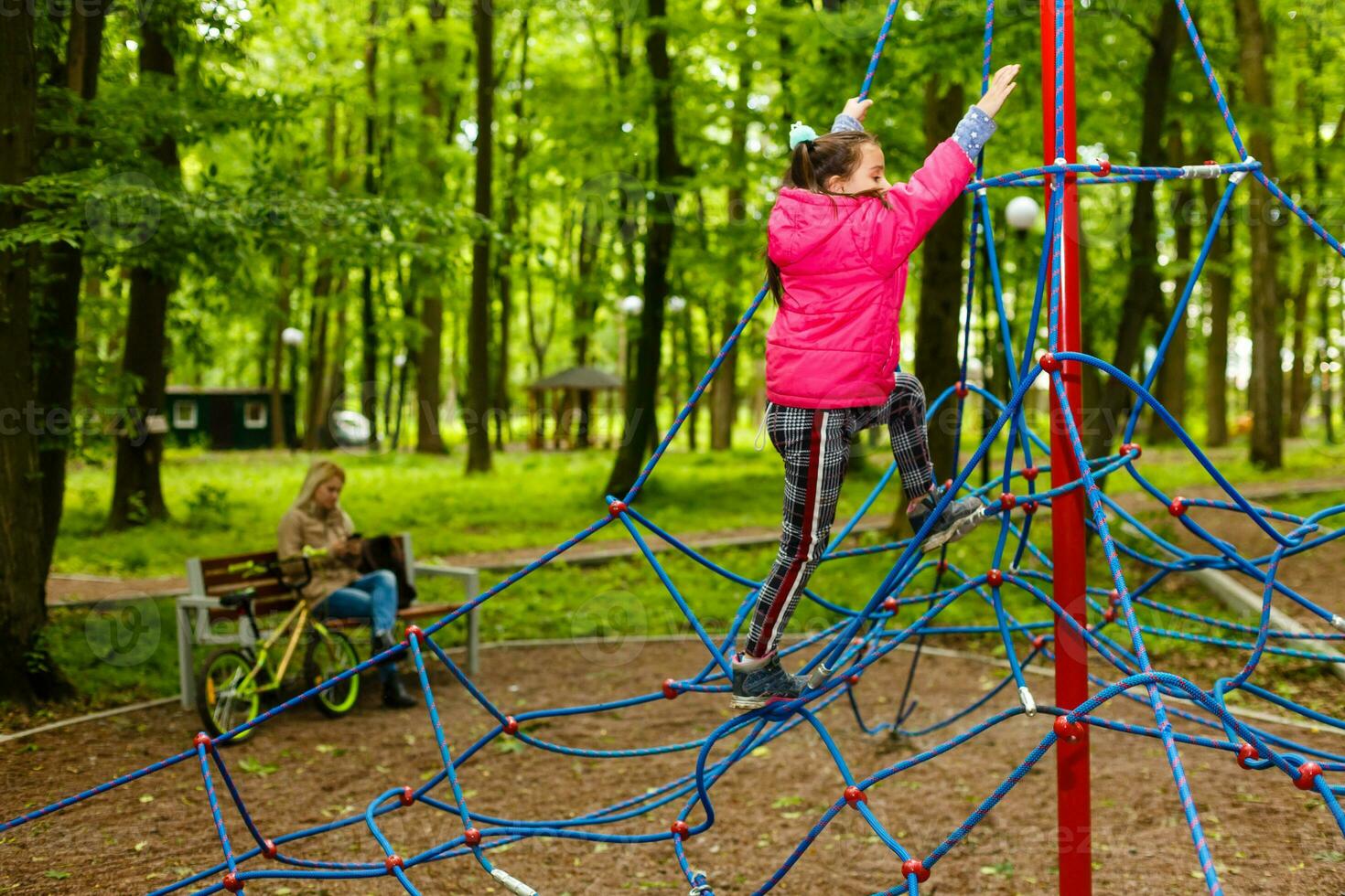 Adorable little girl enjoying her time in climbing adventure park photo
