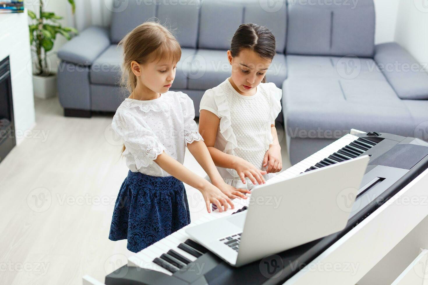Home lesson on music for the girl on the piano. The idea of activities for the child at home during quarantine. Music concept photo