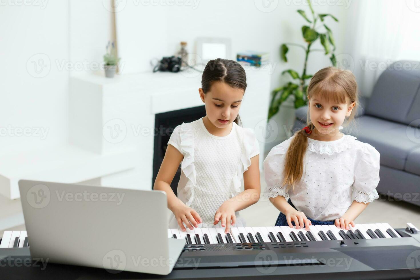 Home lesson on music for the girl on the piano. The idea of activities for the child at home during quarantine. Music concept photo