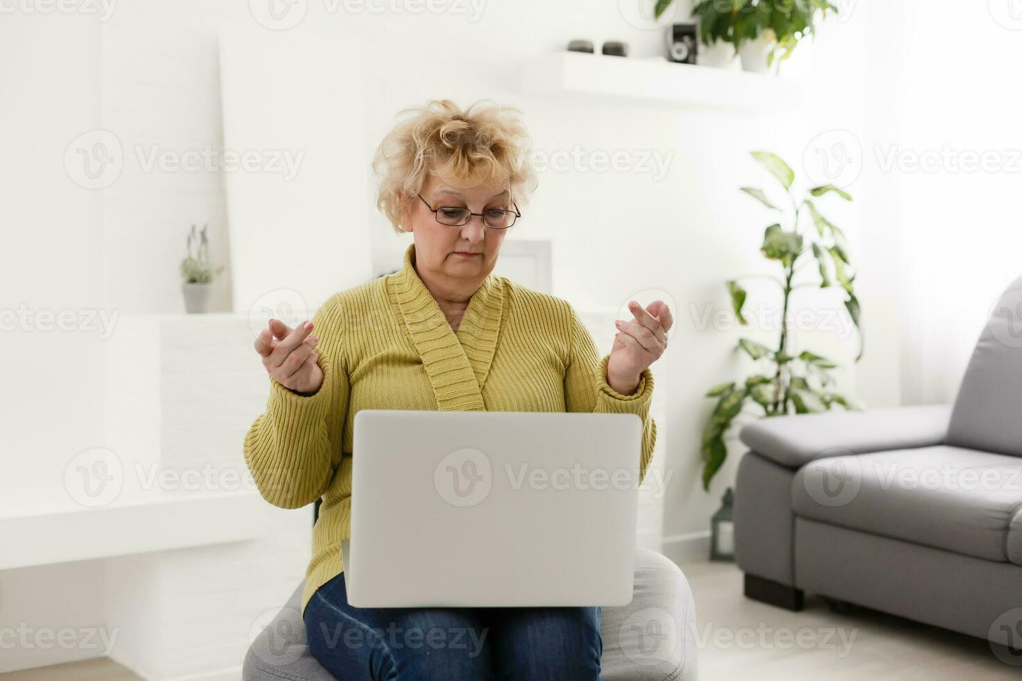 Shocked middle aged mature woman feeling stressed reading unbelievable online news, surprised senior old lady looking at laptop amazed by unexpected stuck computer problem sit on sofa at home photo