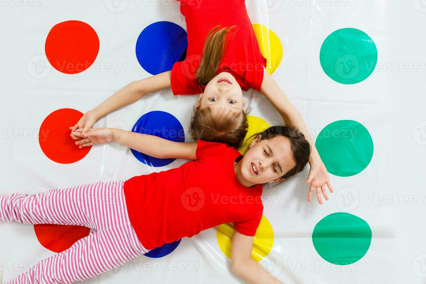two little girls Having Fun Playing Game On Floor At Home. Siblings Friendship photo