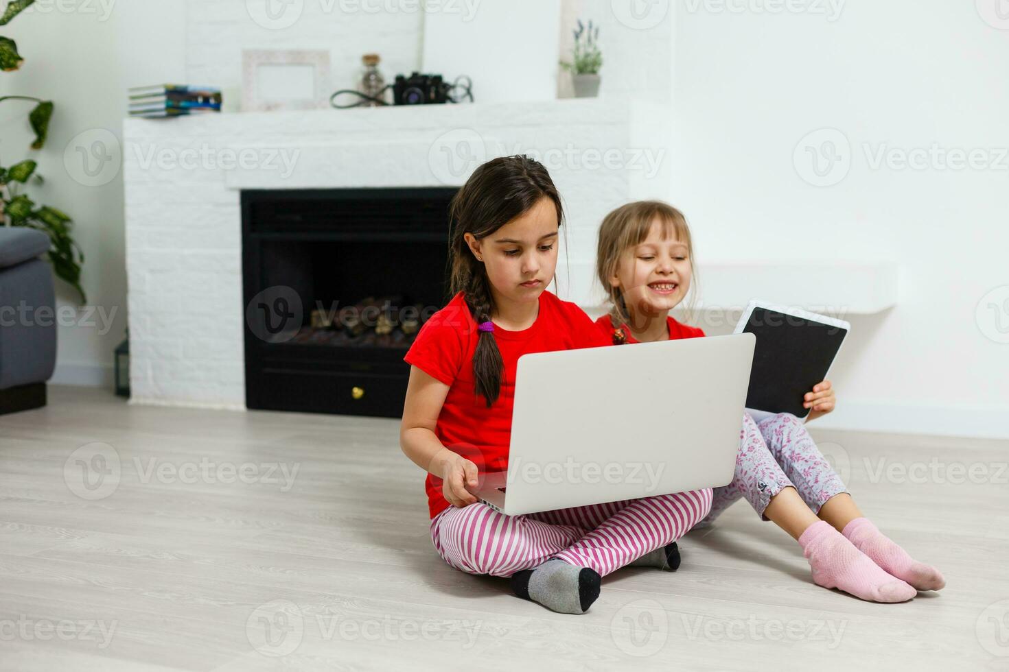 Two little girls sitting in front of a laptop and laughing, close-up, positive emotions, entertainment on the Internet for children photo
