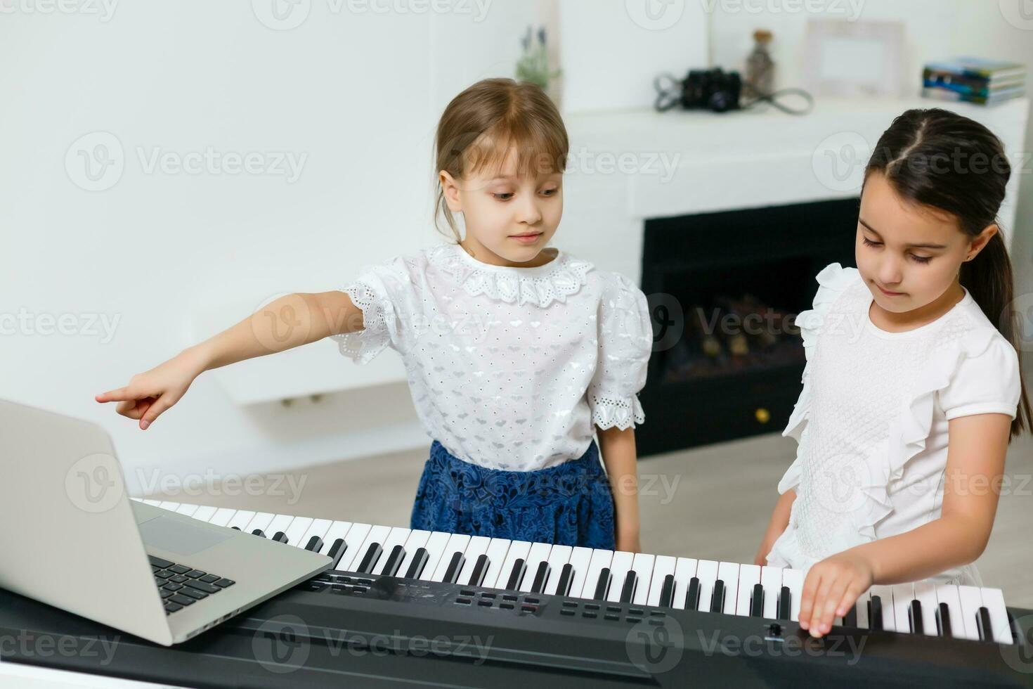 Home lesson on music for the girl on the piano. The idea of activities for the child at home during quarantine. Music concept photo