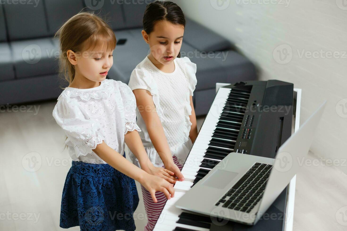 Home lesson on music for the girl on the piano. The idea of activities for the child at home during quarantine. Music concept photo