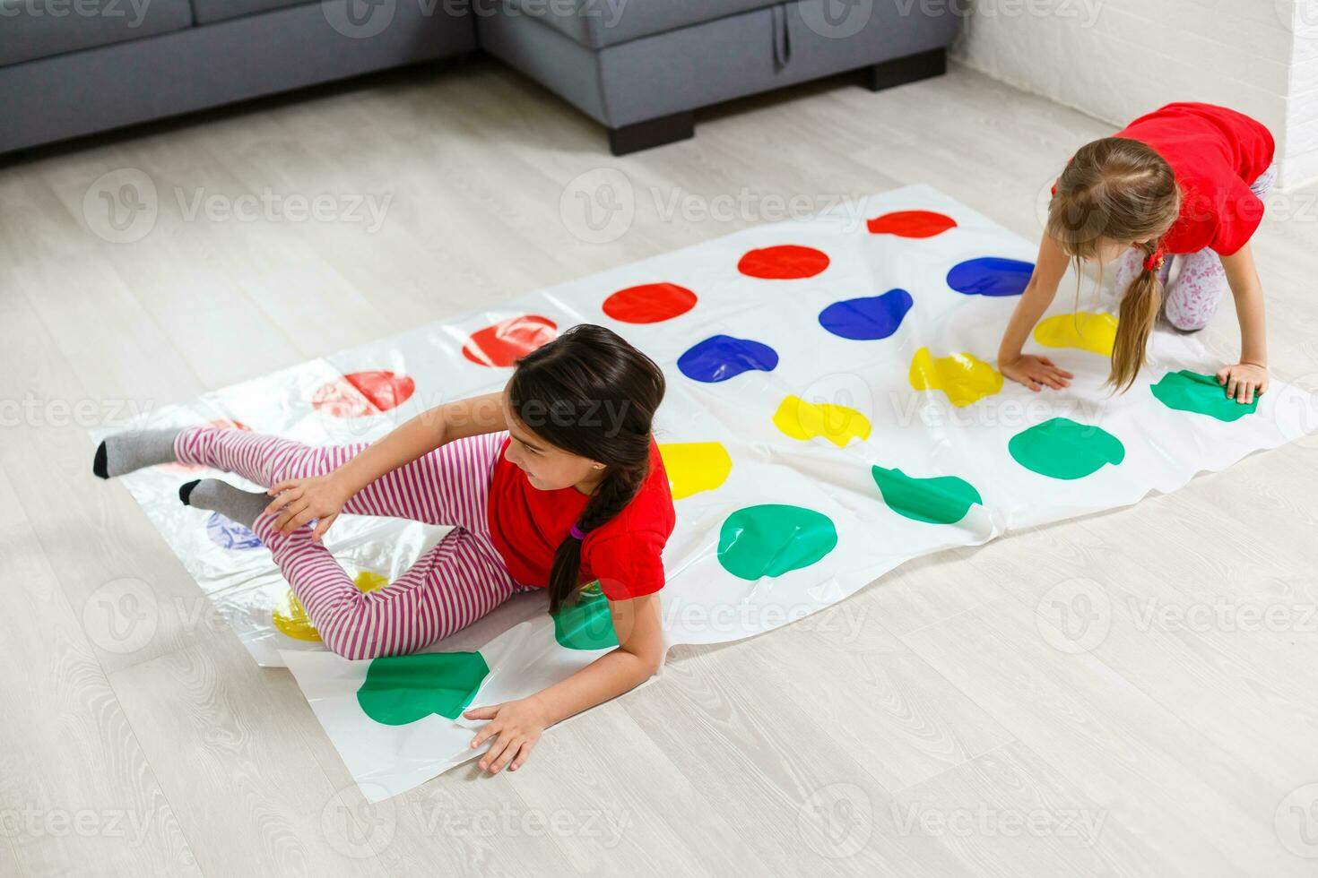two little girls Having Fun Playing Game On Floor At Home. Siblings Friendship photo