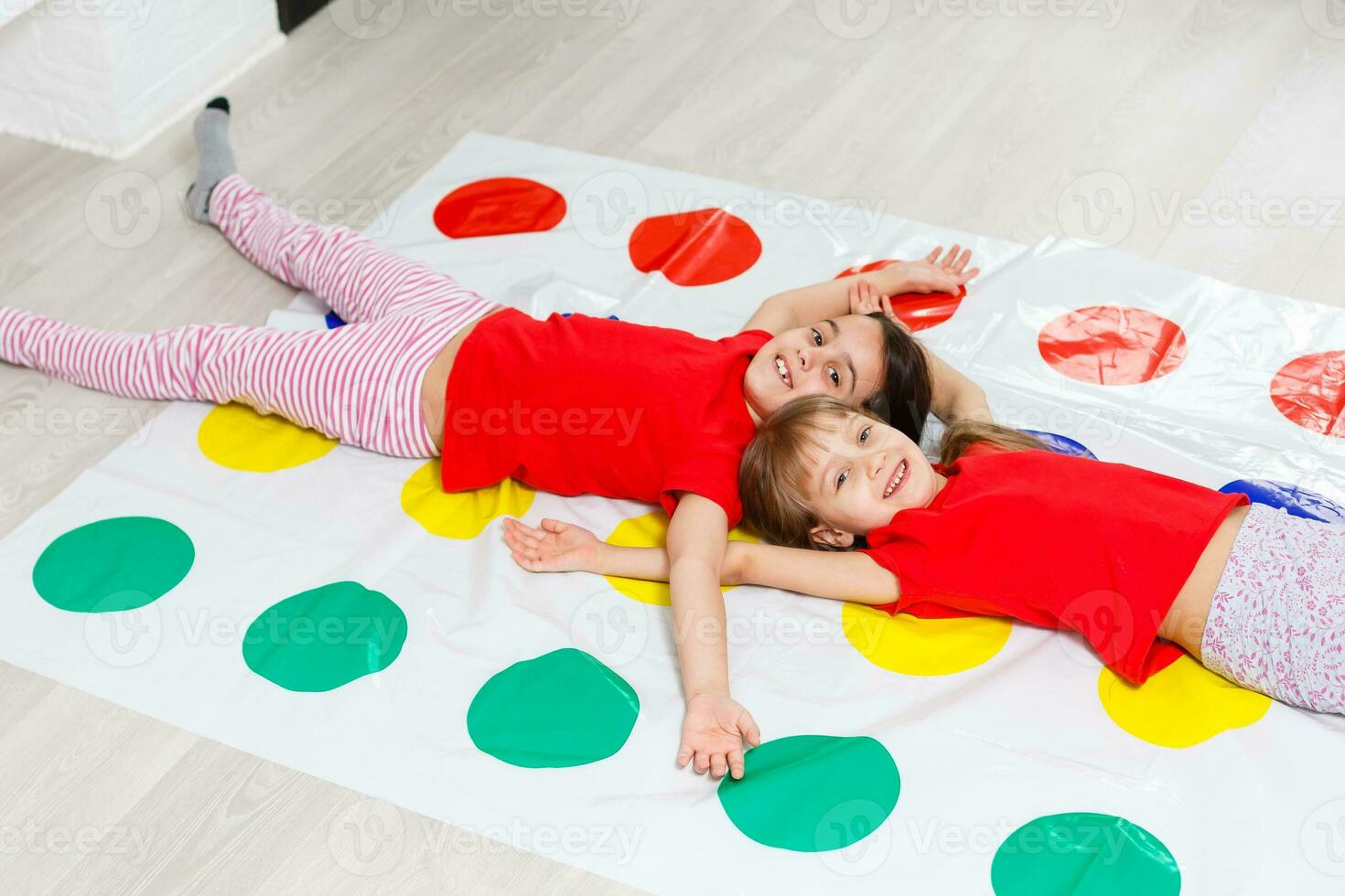 two little girls Having Fun Playing Game On Floor At Home. Siblings Friendship photo