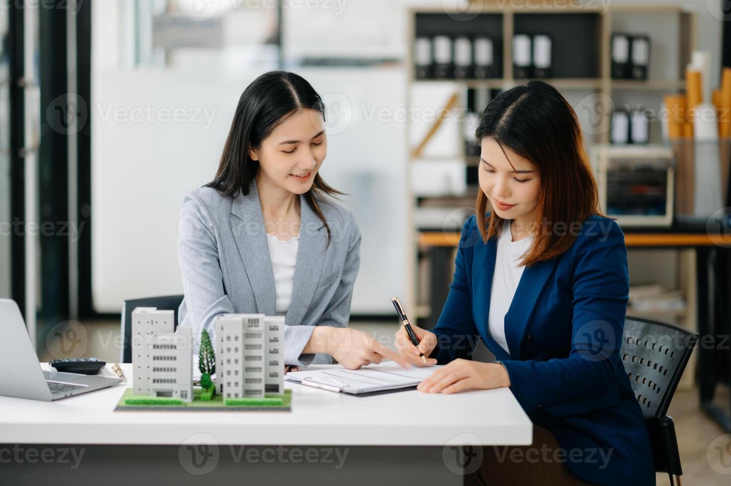 Signing a contract. Client and broker agent, lease agreement, successful deal and  Young business sitting in office photo