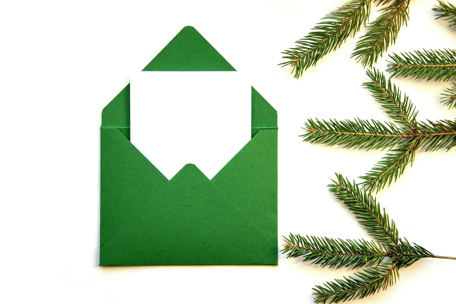 Creative layout made from a Christmas tree branch and a handmade envelope. Place for text. photo