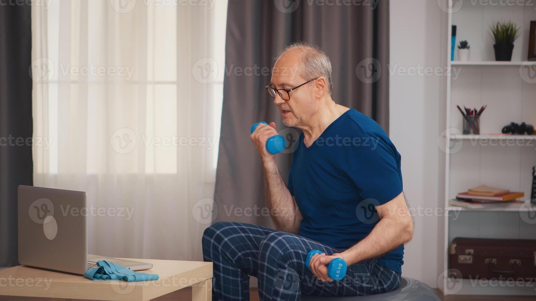 Healthy senior man training following online fitness lesson. Old person pensioner healthy training healthcare sport at home, exercising fitness activity at elderly age photo