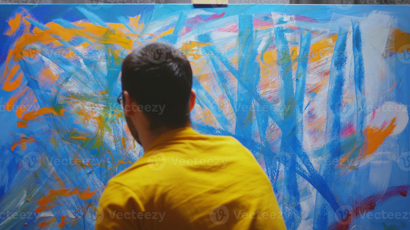 Male artist painting in studio with hands on canvas. photo