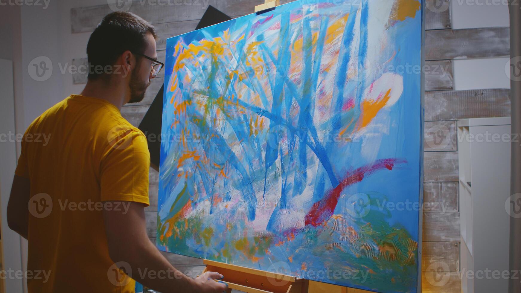 Artist paints on large canvas with fingertips in art studio. photo