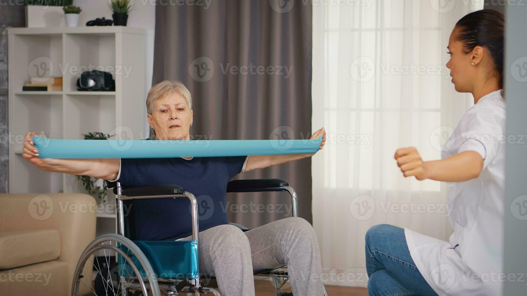 Senior woman in wheelchair doing rehabilitation treatment with assistance from nurse. Training, sport, recovery and lifting, old person retirement home, healthcare nursing, health support, social assistance, doctor and home service photo