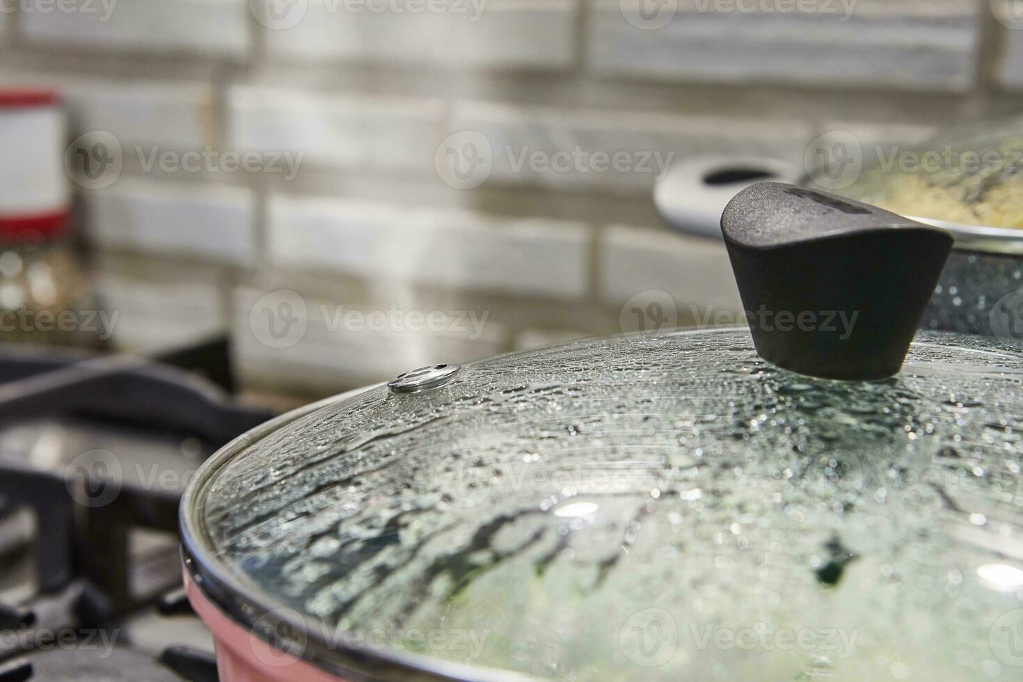 Close-up of Frying Pan Lid with Rising Steam and Water Droplets photo