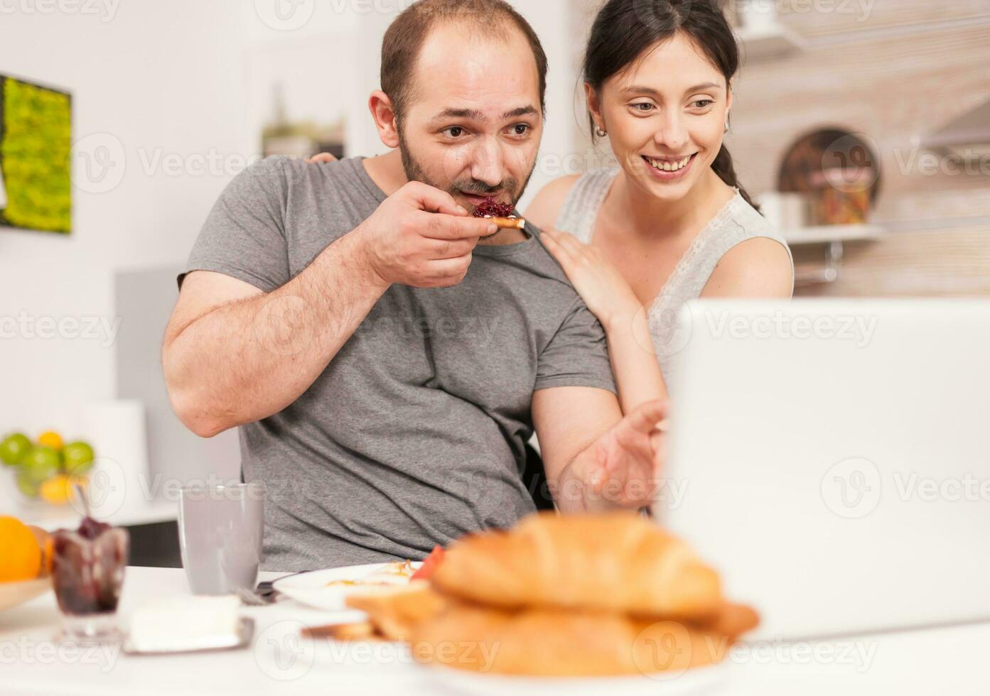 joven familia recepción bueno Noticias en correo electrónico en el Mañana comiendo desayuno. exitoso lleno de alegría eufórico empresario a hogar en el mañana, ganador y negocio triunfo foto