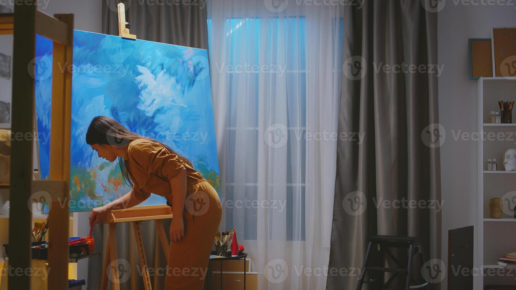 Inspired young painter in her workshop making a masterpiece. photo