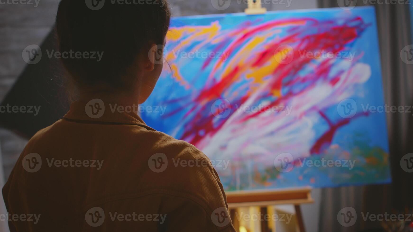 Creative contemporary painter using her imagination on colorful canvas. photo