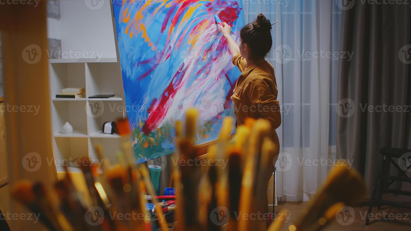 Artist choosing the right paint brush in art studio for her masterpiece. photo