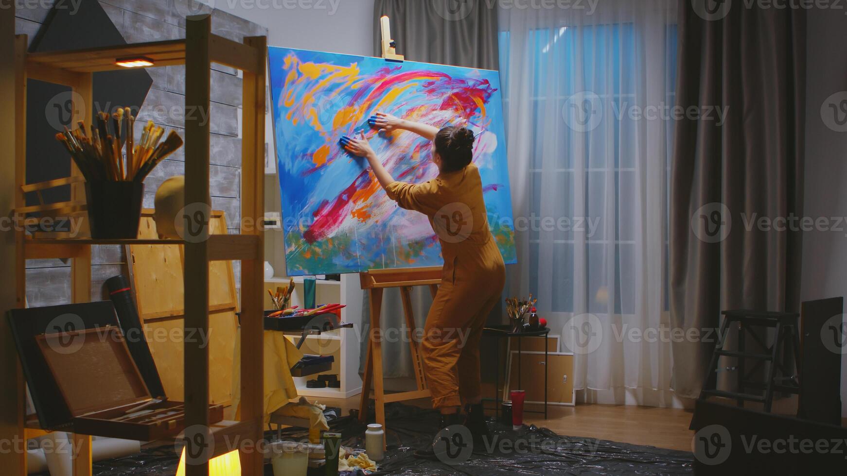 Painter using fingers on large canvas making a masterpiece in art studio. photo