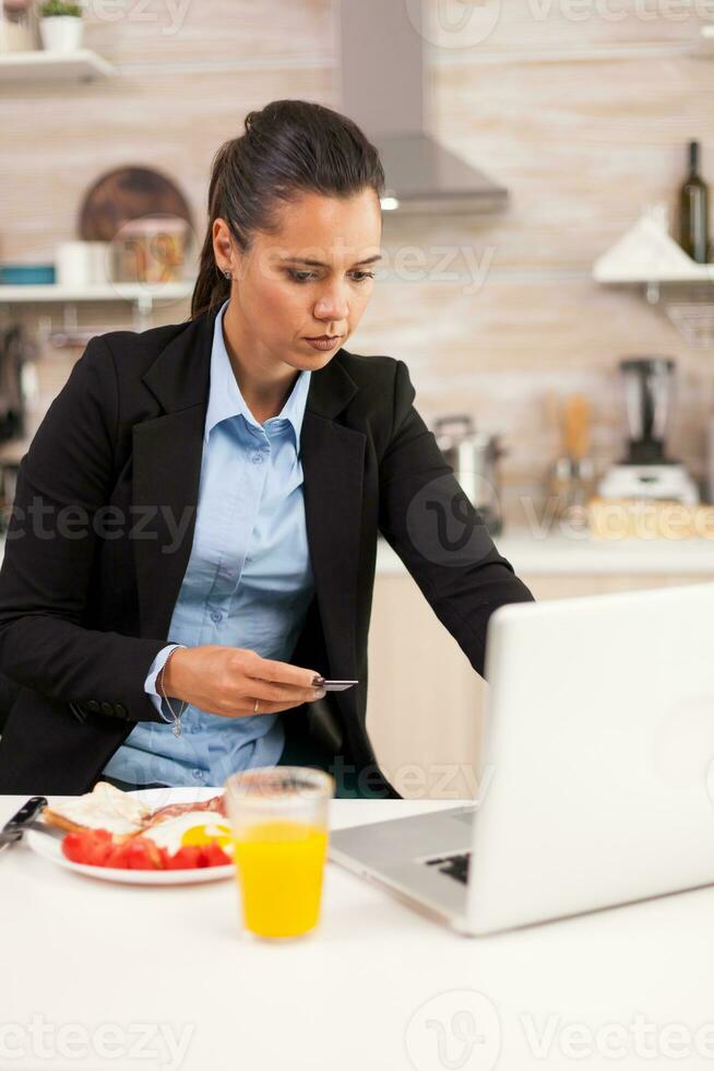 Businessperson checking the card dates before payment. Shopping online for goods and clothes, using modern technology in every day life, making payments via internet. photo