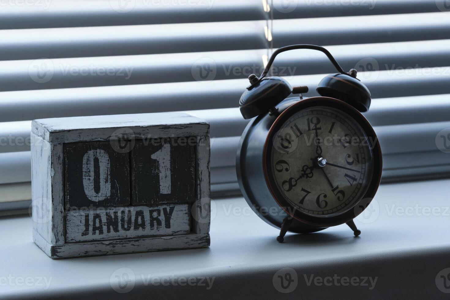 Morning of January 01 on wooden calendar standing window with blinds
