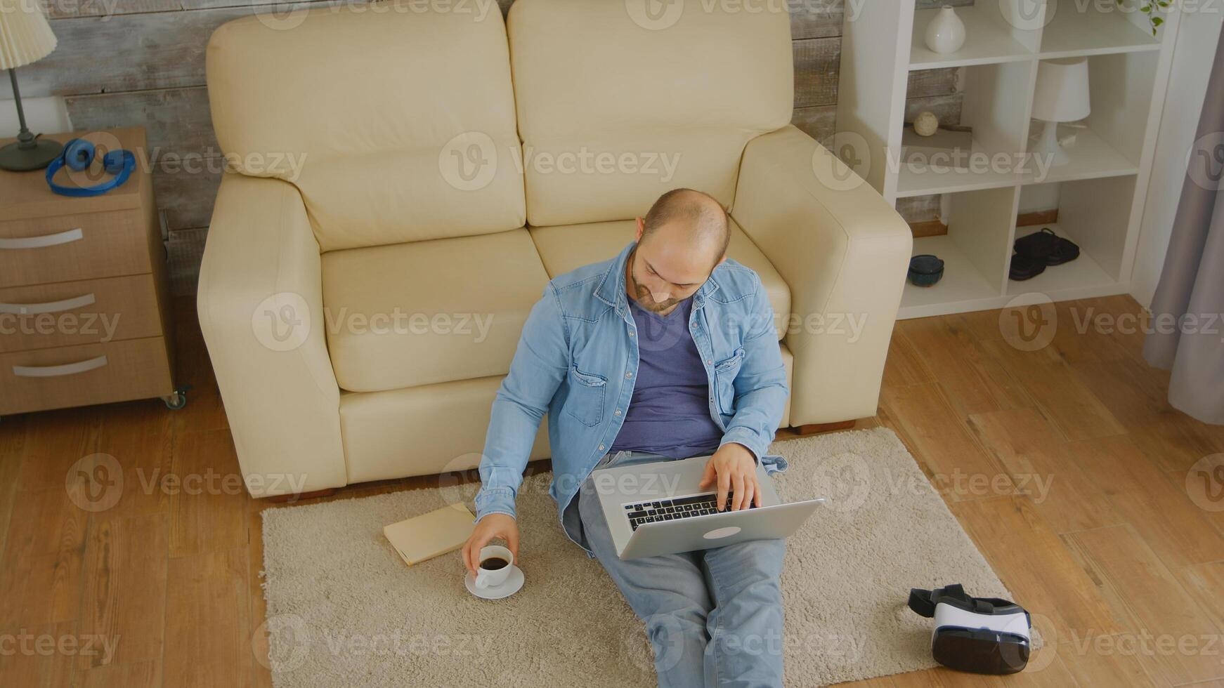 Top view of caucasian man working on laptop and enjoying a cup of coffee photo