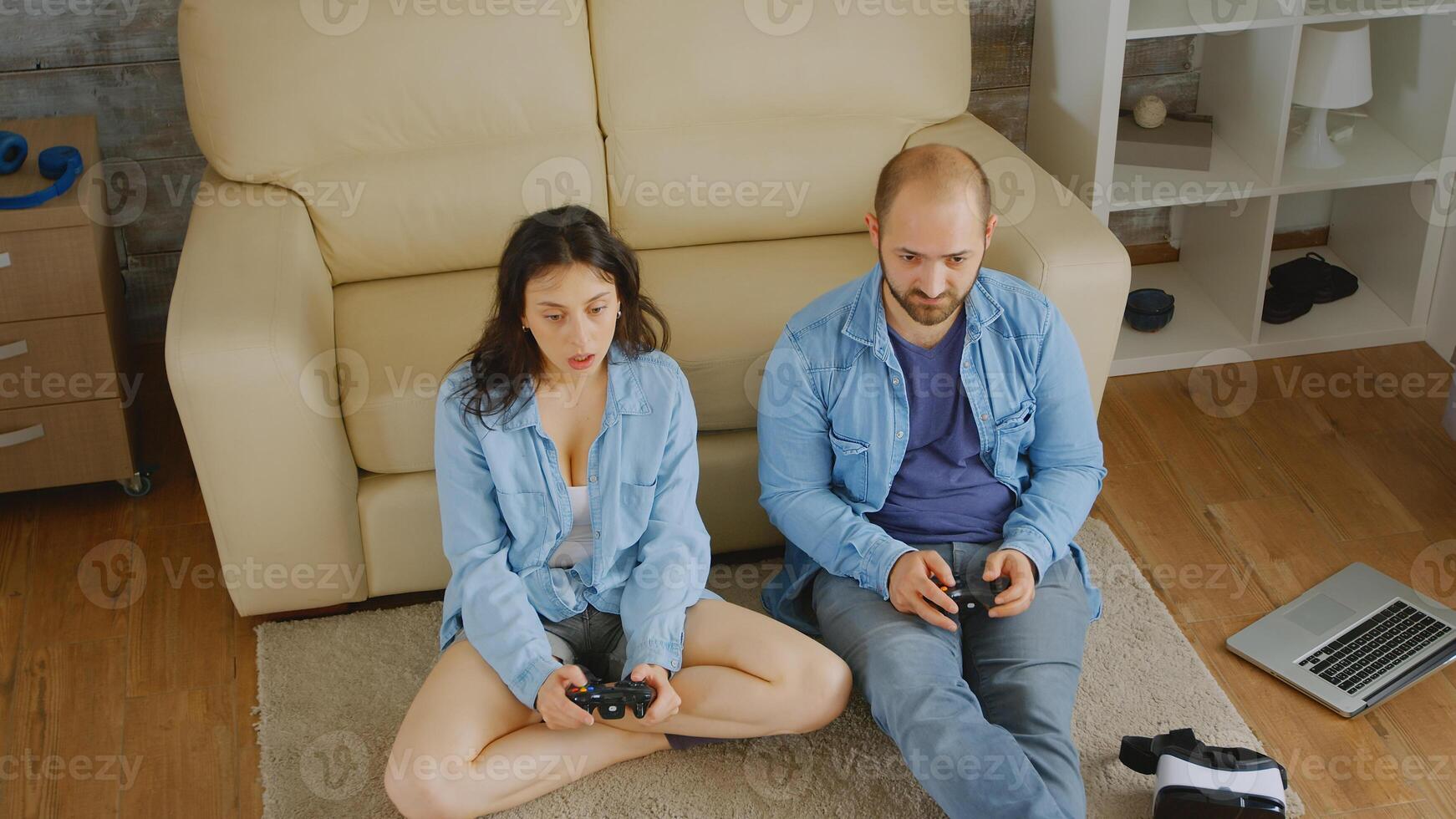 Young couple playing video games with wireless controllers. photo