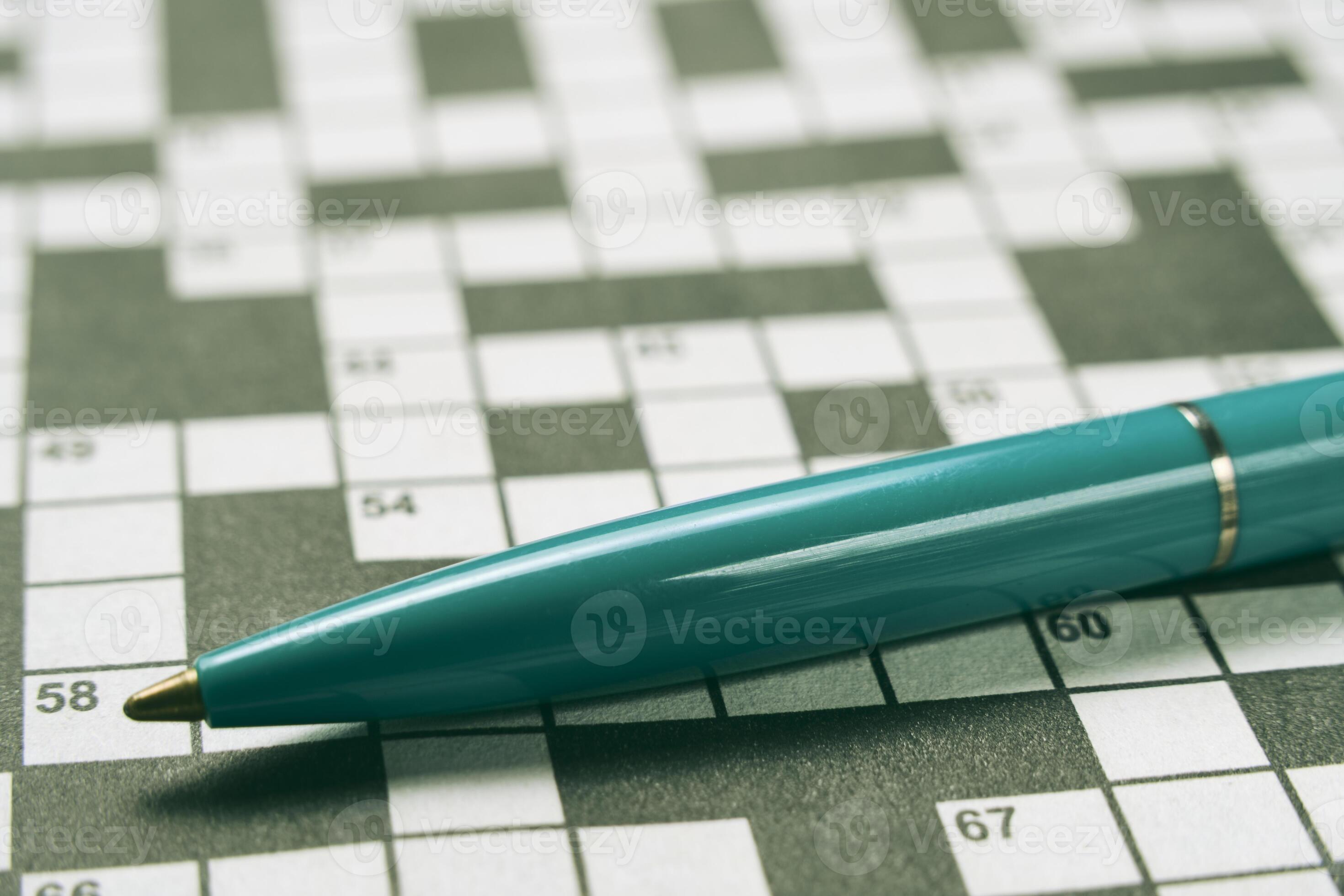 Ballpoint pen is lying on piece with crossword puzzle.Hobby concept and