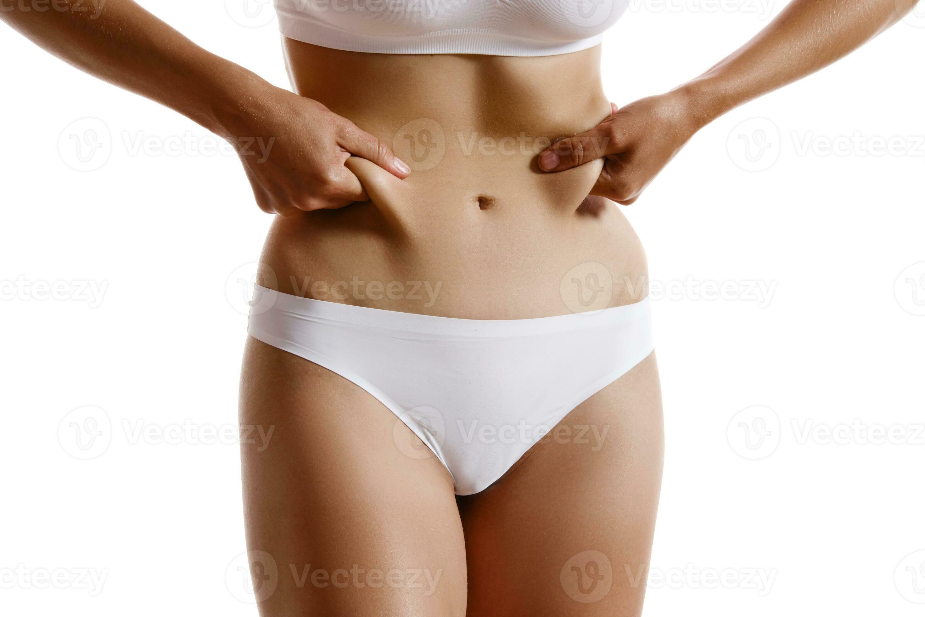 Young body of girl in white underwear, showing fat on her belly, posing  isolated on white. Plastic surgery, aesthetic cosmetology concept.  Close-up. 35179020 Stock Photo at Vecteezy