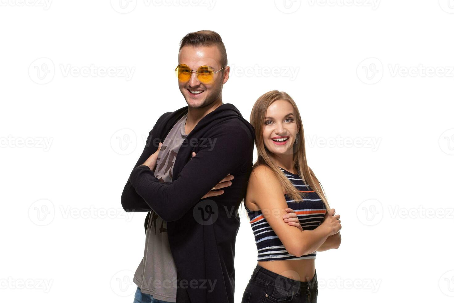 Studio shot of beautiful young couple standing back to back and looking at the camera photo